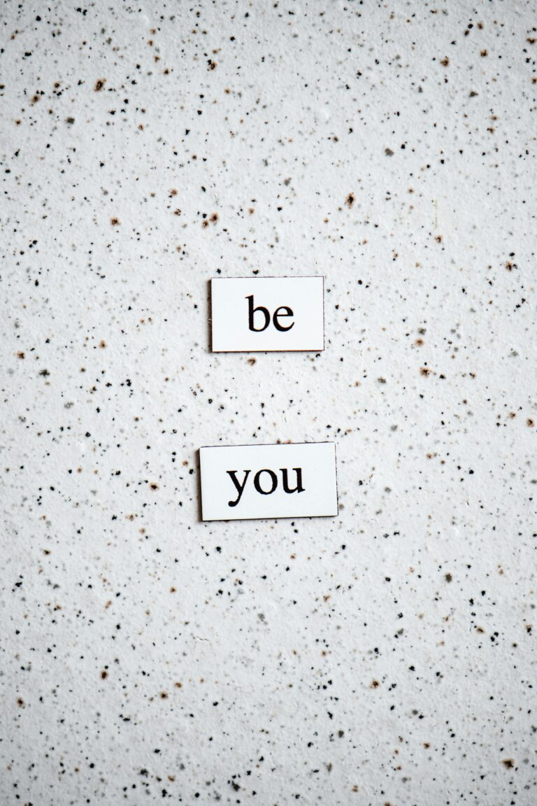 Simple 'Be You' message on a speckled monochrome background for motivation and inspiration.