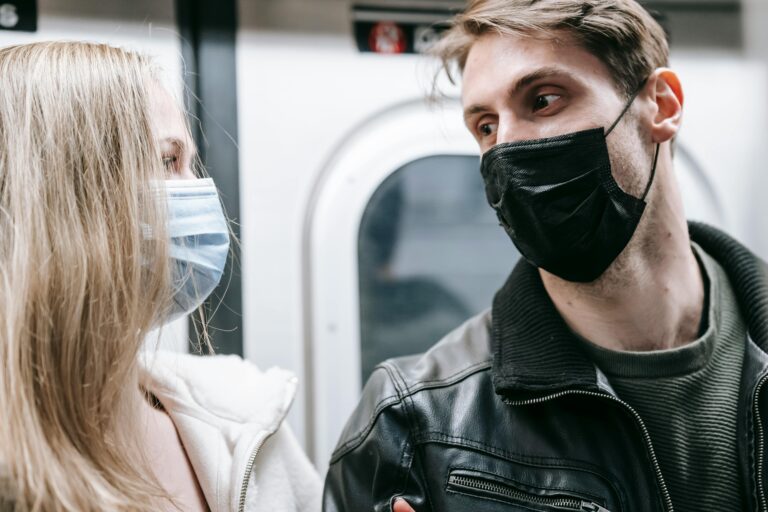 Couple wearing masks engaging in conversation on a subway. New normal lifestyle.